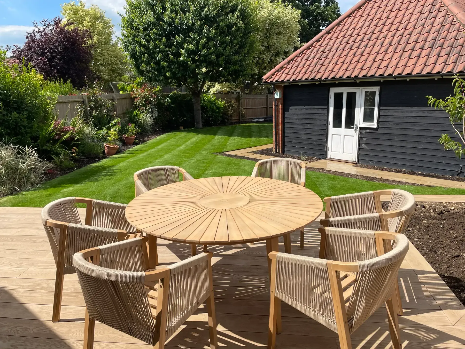 Limestone patio and pergola creating a sunny family seating area in Broomfield garden
