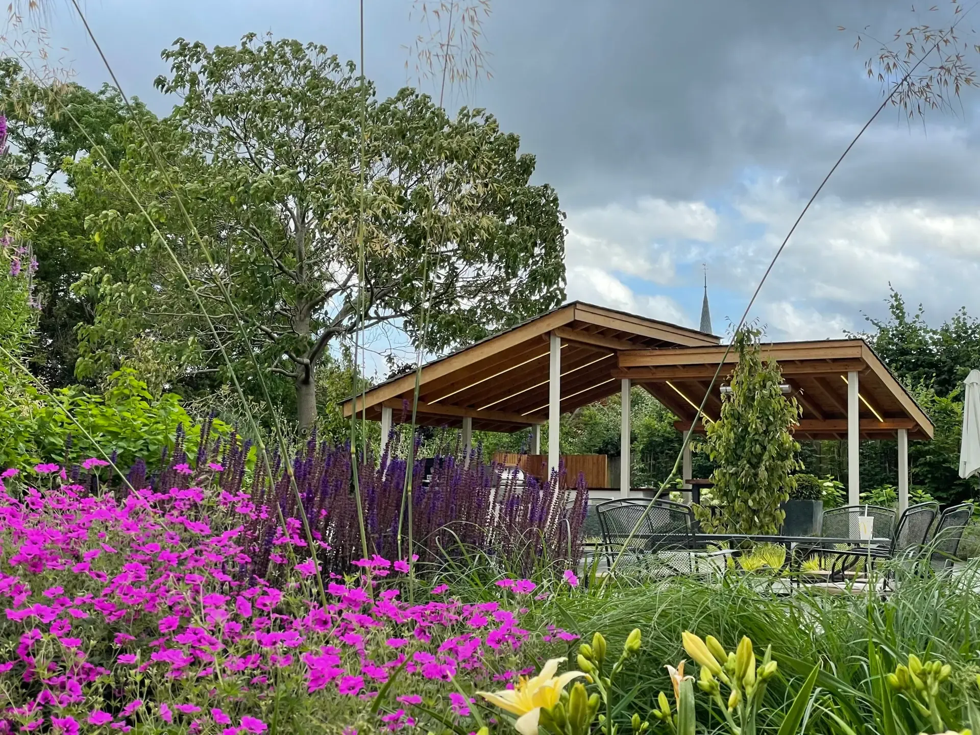 Soft, layered planting alongside a garden lawn