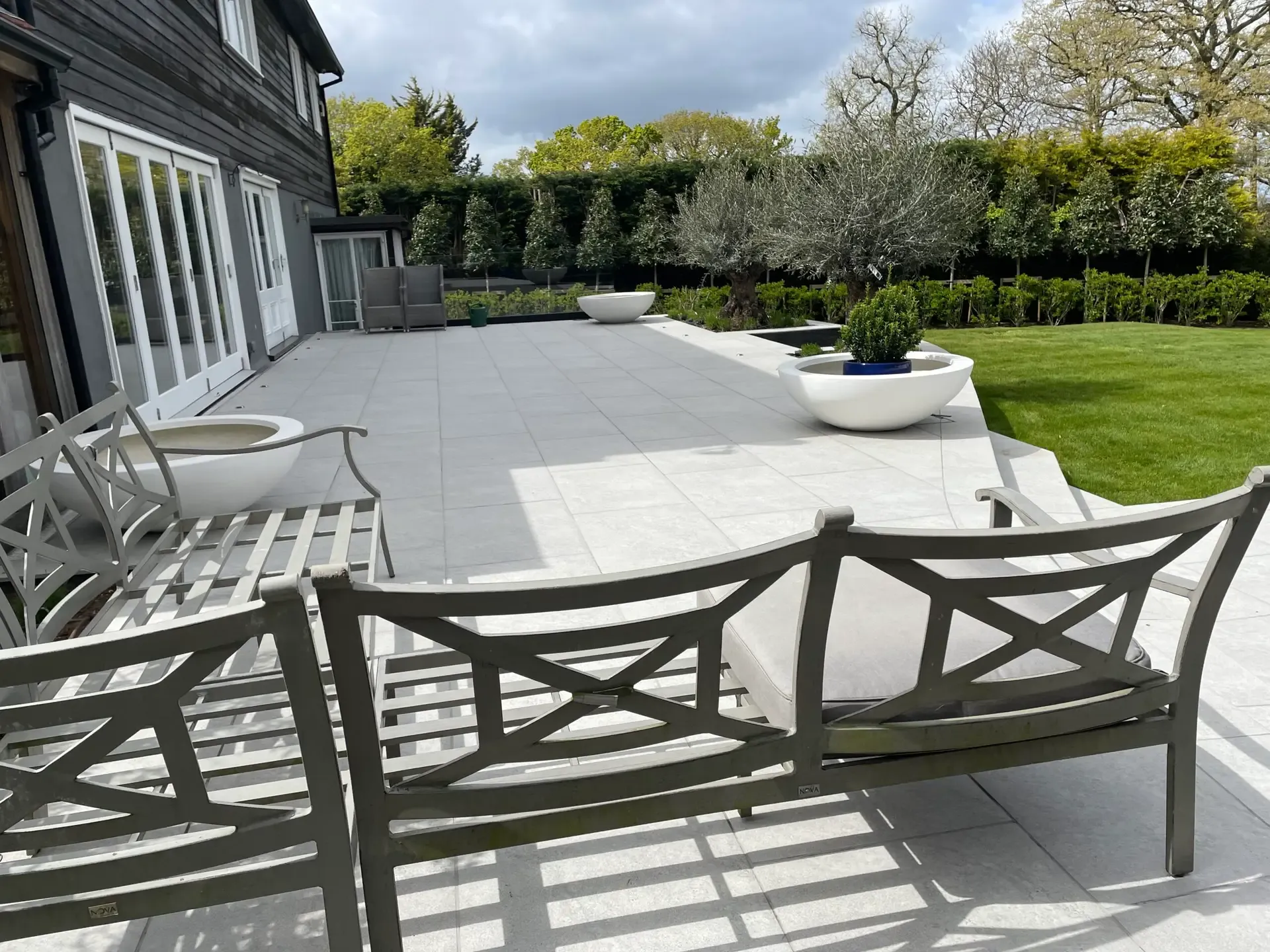 Curved slate-clad retaining walls defining the raised terrace in Danbury, Essex