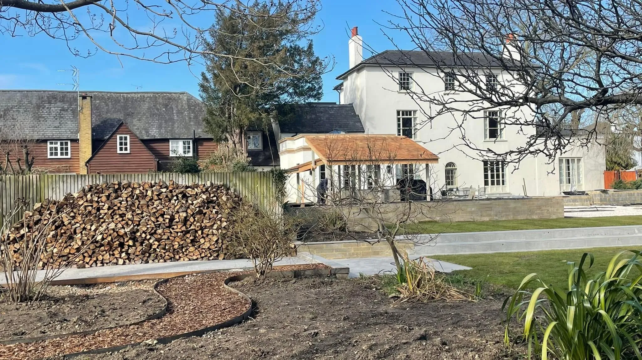 Woodland-inspired lower garden in Sawbridgeworth with bark paths and trees